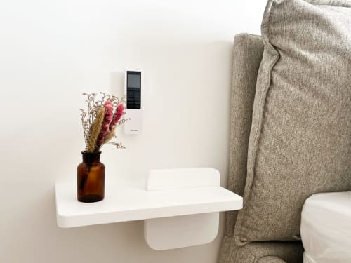 Étagère murale moderne avec fleurs séchées dans un vase ambre à côté d'un fauteuil beige à l'hôtel Anne Duval, Saint-Florent