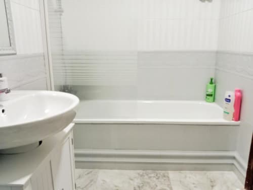 Baño limpio con lavabo blanco, bañera y artículos de aseo en el apartamento Top Home Integra de Jerez de la Frontera