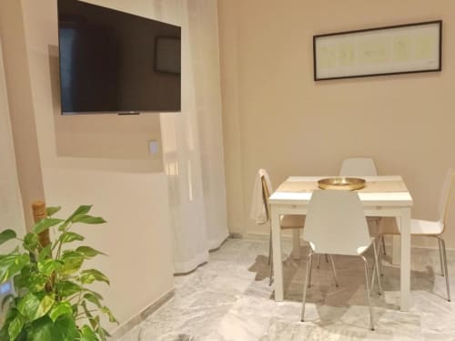 Área de comedor moderno en Top Home Integra de Jerez de la Frontera con mesa blanca, sillas, planta verde y