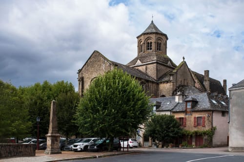 Église en pierre historique avec tour conique à Aubazine, France, près de la Résidence hôtelière du Coiroux