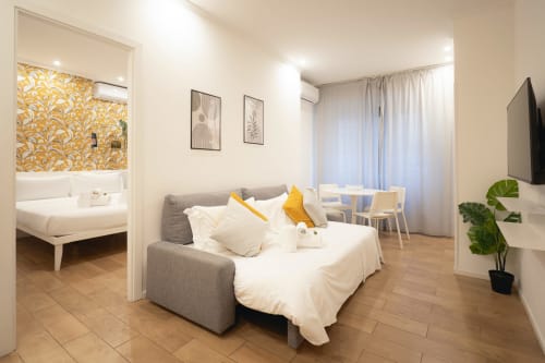Modern studio apartment at IV House B&B a Roma con divano letto, biancheria bianca, dettagli gialli e camera da letto separata