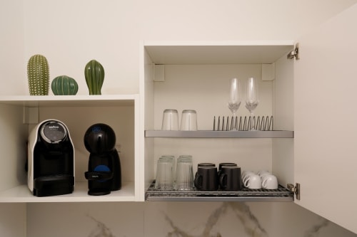 Scaffali della cucina di House IV Roma con cactus, macchinette da caffè e vetri organizzati