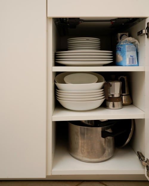 Cucina della IV House Roma con credenza con piatti impilati, ciotole, stoviglie e forniture