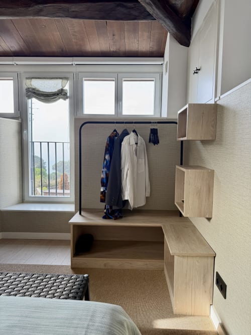 Dormitorio moderno en Casa Rural San Andrés de Teixido con armario de madera, vistas al mar y mobiliario minimalista