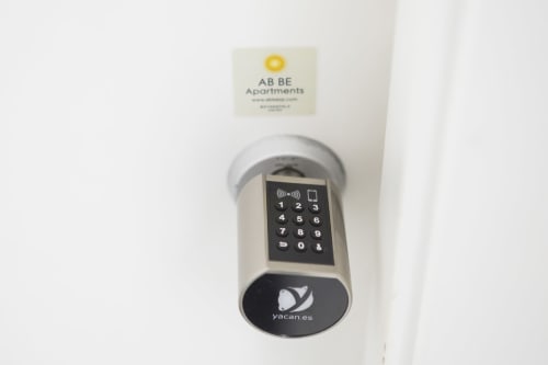 Cerradura digital con teclado numérico en Ab Be Apartments Málaga con branding yacan.es para acceso autónomo
