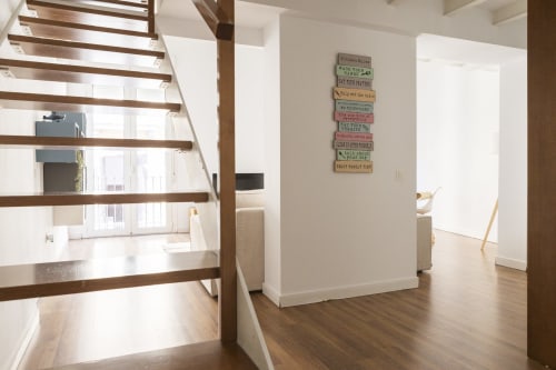 Moderno loft en Málaga con escaleras de madera, sala abierta y señalización motivacional en Ab Be Penthouse.