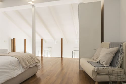 Dormitorio moderno en ático de Ab Be Apartments en Málaga con armarios espejados, suelos de madera y mobiliario contemporáneo
