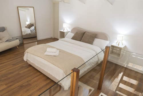 Dormitorio moderno en penthouse Ab Be de Málaga con vistas a la ciudad, suelos de madera y mobiliario contemporáneo