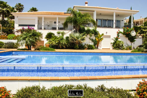 Modern white villa with swimming pool, palm trees, and Mediterranean architecture in Spain