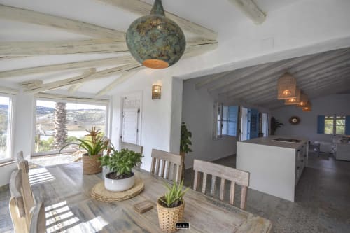 Bright Mediterranean hotel dining area with wooden beams, potted plants, and valley views at Escanda Building Solutions