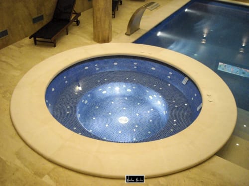 Modern spa pool with illuminated blue mosaic tiles and embedded lights at Escanda Building Solutions hotel in Spain