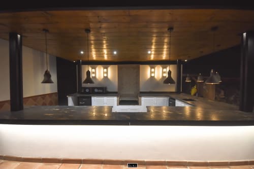 Modern hotel bar counter with pendant lighting, wood ceiling, and ambient fixtures at Escanda Building Solutions