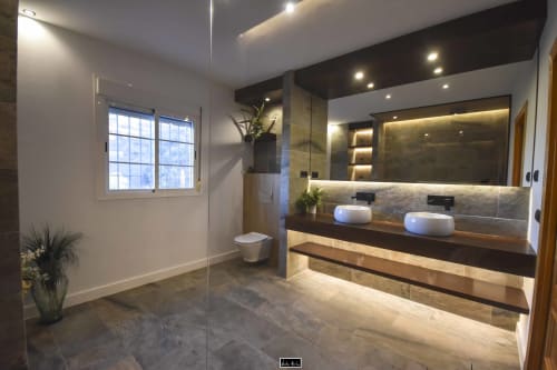 Modern luxury bathroom at Escanda Building Solutions hotel with double vanity, heated mirrors, rainfall shower, and natural