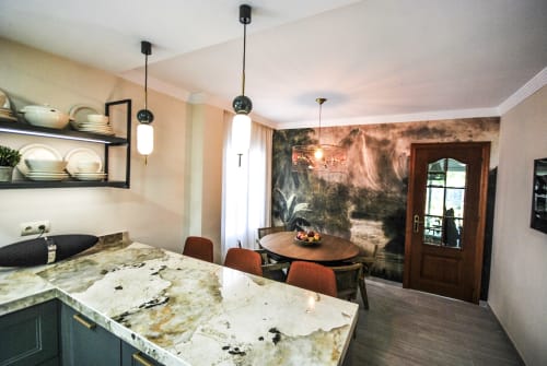 Modern hotel kitchen and dining area with granite countertops, pendant lighting, and nature wallpaper at Escanda Building
