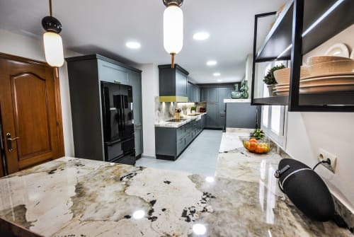 Modern kitchen with black cabinets, marble countertop, and pendant lighting at Escanda Building Solutions hotel in Spain