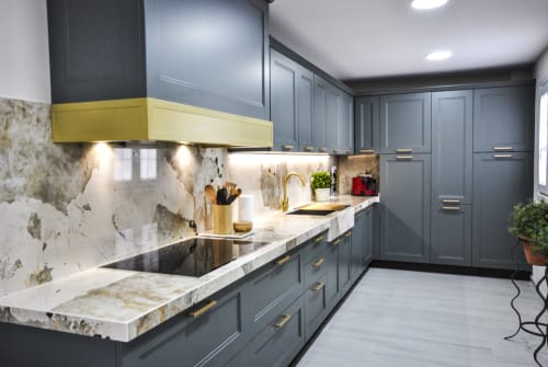 Modern kitchen with gray cabinetry, yellow accents, marble countertops and backsplash at Escanda Building Solutions hotel in