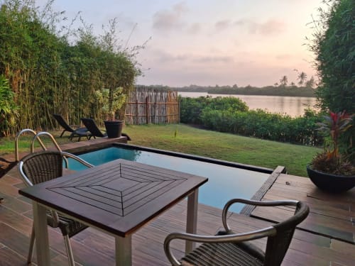 Pooldeck des Isla Tajín Beach & River Resort mit Blick auf den Tuxpan-Fluss bei Sonnenuntergang, mit Liegen und Garten