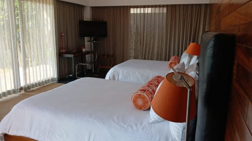 Modernes Hotelzimmer im Isla Tajín Beach & River Resort in Tuxpan mit zwei Betten, orangefarbenen Akzenten und großen Fenstern