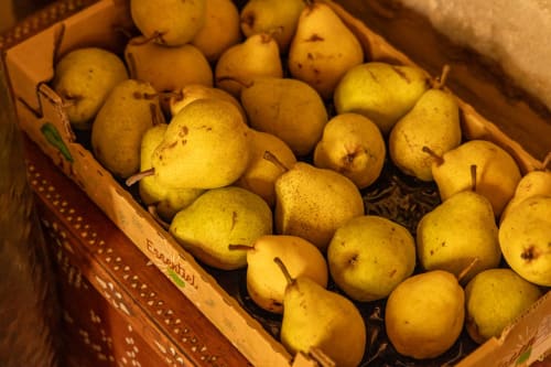 Fresh pears in a woven basket at Le Prieuré Notre-Dame B&B in Montfrin, France