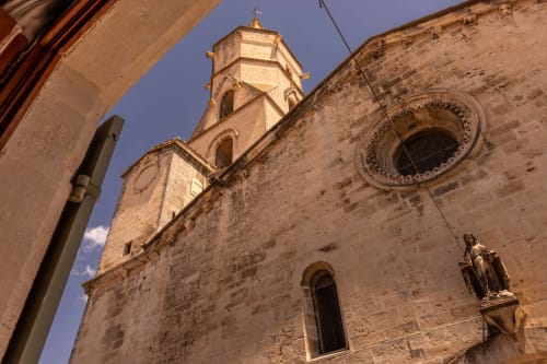 Historic stone church facade with tower in Montfrin, France near Le Prieuré Notre-Dame