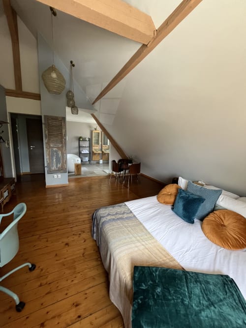 Chambre spacieuse sous les toits à Théière & Couverts à Cernay avec poutres apparentes, parquet et décoration moderne