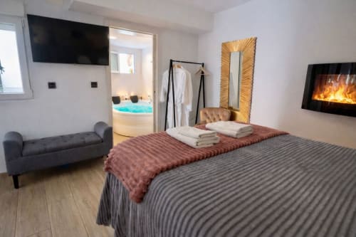 Moderno apartamento de hotel en Mérida con cama, TV, chimenea, acceso a jacuzzi y vistas a la ciudad