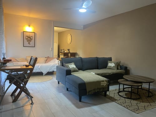 Grand salon ouvert avec espace bureau dédié et couchages supplémentaire.