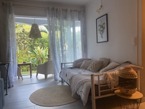 Couchage pour une personne dans le salon, avec vue sur jardin.