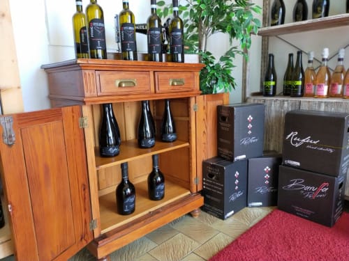 Esposizione di vini con mobile in legno e bottiglie a Casa Meravigliosa a Fontanafredda, Pordenone
