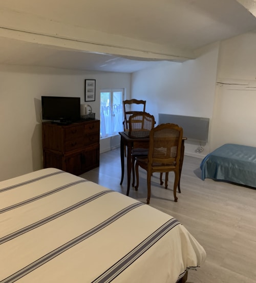 Espace salon et bureau de la chambre d'hôtes familiale Océane à La Maison d'hôtes  La Chabanaise - marais poitevin, avec poutres apparentes, lit principal.