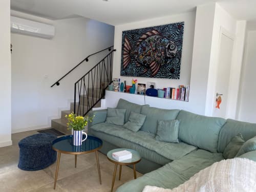 Modern living room with sage green sofa, wooden tables, and contemporary artwork in Villa Ô Bord de Mer, managed by Corsu Di Core