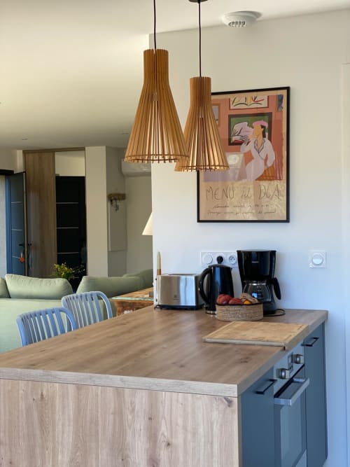 Modern kitchen with wooden pendant lights, island counter, and dining area in Villa Ô Bord de Mer, managed by Corsu di Core
