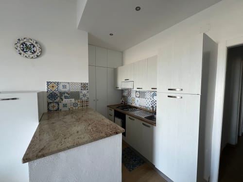 Cucina moderna con cabinetry bianco, piastrelle decorate, piano in granito e fornello a gas fronte mare a Marina di Strongoli