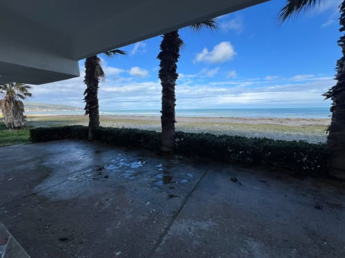 Patio coperto sulla spiaggia con palme con vista sulla costa di Marina di Strongoli, Italia
