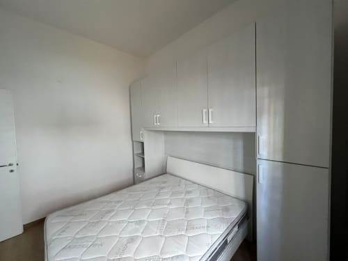 Camera da letto moderna con armadio bianco, letto matrimoniale e design minimalista all'appartamento Marina di Strongoli