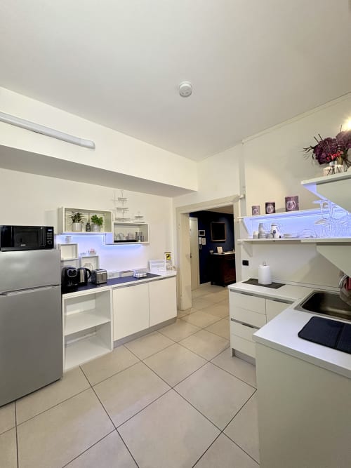 Cucina moderna nella suite Nabucco di Il Tenore B&B, Verona. Cabinetry bianca, elettrodomestici in acciaio inox, illuminazione blu.
