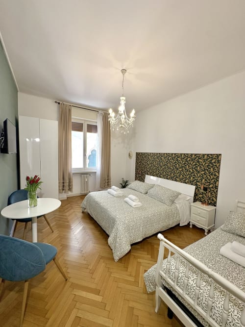 Camera elegante all'Il Tenore B&B a Verona con letto matrimoniale, lampadario, pavimento a spina di pesce e vista sulla città