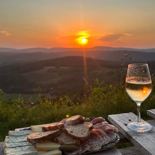 Vino y charcutería al atardecer en Cabanes et lodges du Belvédère con vistas al valle del Ain