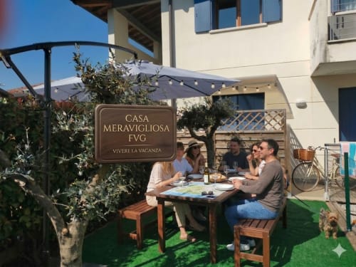 Ospiti cenano sulla terrazza di Casa Meravigliosa, villa vacanziale a Fontanafredda con posti a sedere esterna e ombrelloni