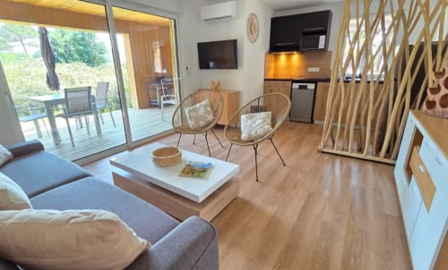 Appartement studio moderne à ALMA ROSSA à Lecci avec séjour ouvert, kitchenette, parquet et accès à la terrasse.