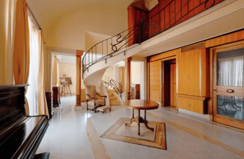 Ampio loft moderno con scala a spirale, porte in legno e arredi mid-century nell'hotel di Catania