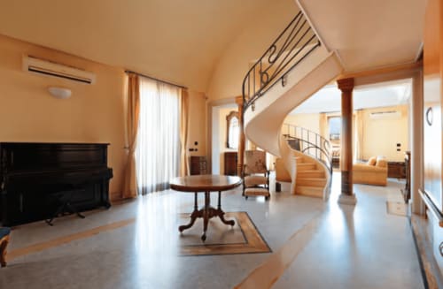 Ampio soggiorno con scala a spirale, pianoforte e arredamento moderno presso l'Aparthotel Bentivoglio, Catania