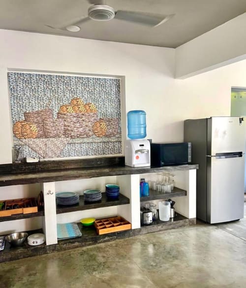 Cocina Casa Tsuki con refrigerador, dispensador de agua, azulejos de mosaico y repisa organizada en cabaña de Puerto Escondido