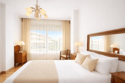 Luminoso dormitorio en apartamento de Baiona con cama queen, vistas a la ciudad, muebles de madera y comodidades modernas