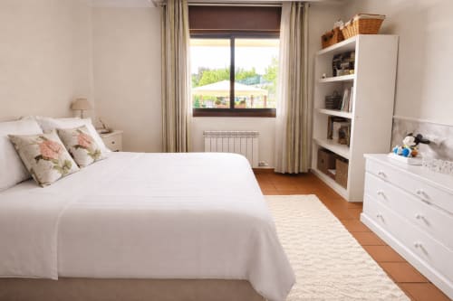 Dormitorio luminoso en la cabaña Holibai Feiticeira, Baiona: cama blanca, suelos de madera, vistas a montañas y mobiliario moderno