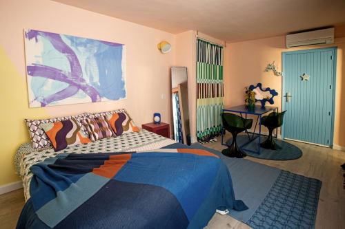 Dormitorio colorido Soul Refuge en Formentera Especial con ropa de cama azul, almohadas vibrantes y puerta turquesa en La Savina