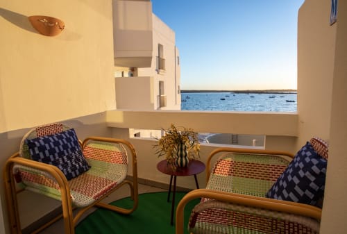 Asientos en la terraza de Formentera Especial con vistas al mar, sillas coloridas y aguas azules del Mediterráneo