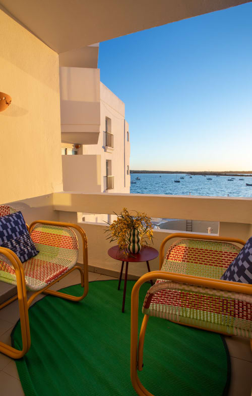 Balcón con sillas de colores y vistas al mar en el hotel Formentera Especial, La Savina