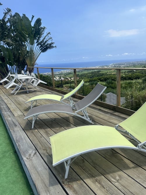 Chaises longues sur terrasse en bois avec vue océanique à l'Hôtel le soleil couchant, Saint-Pierre, La Réunion
