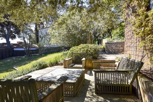 Espace de détente ombragé à l'hôtel Finques Garcia Enrich à Palafrugell avec bancs en bois et jardins luxuriants